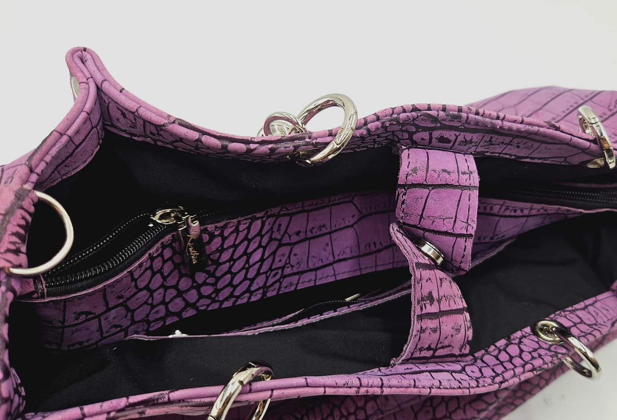 Interno della borsa Kali malva con fodera scura a contrasto e divisorio centrale con zip.